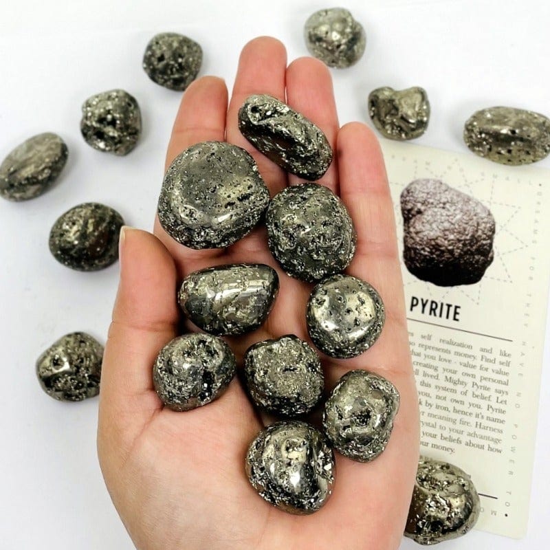 tumbled pyrite on hand with white background