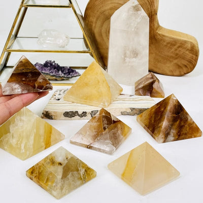 multiple golden healer pyramids displayed to show the differences in the stone sizes and color shades 