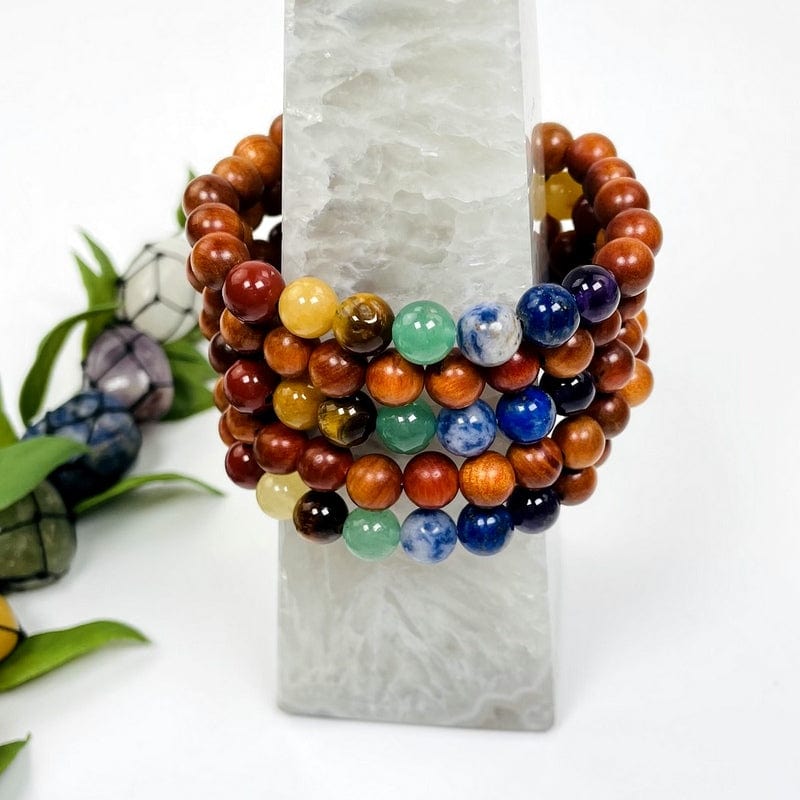 multiple chakra bead bracelets with sandalwood showing both sides of the bracelet 