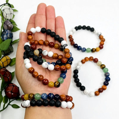 chakra bead bracelets in hand showing different colors and textures 