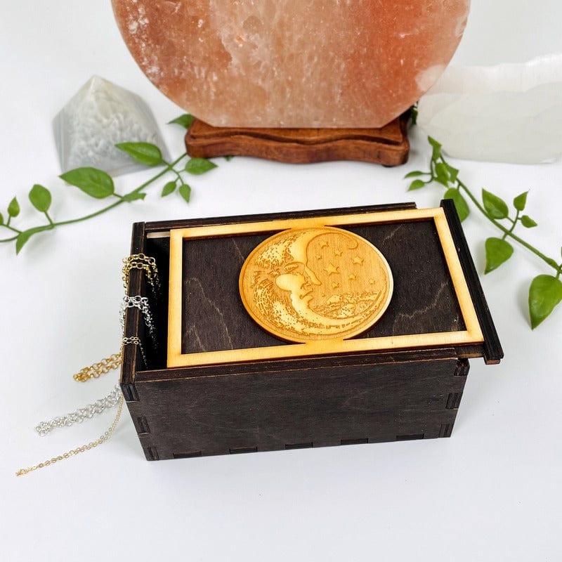 dark wooden storage box with sliding top and an engraved moon 