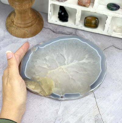 Agate Dish on a concrete background with a hand as a size comparison