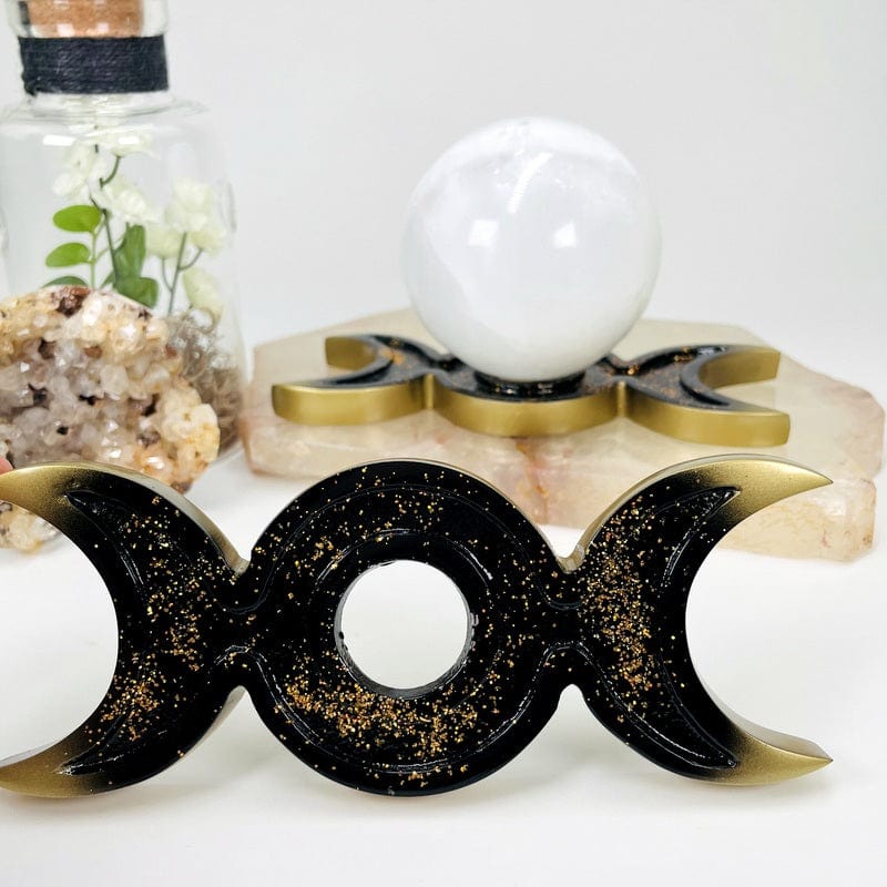 moon phase sphere holder comes in gold and black with a golden glitter accent