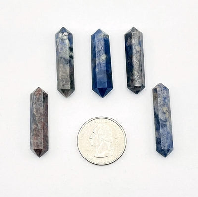 sodalite points next to a quarter for size reference. 