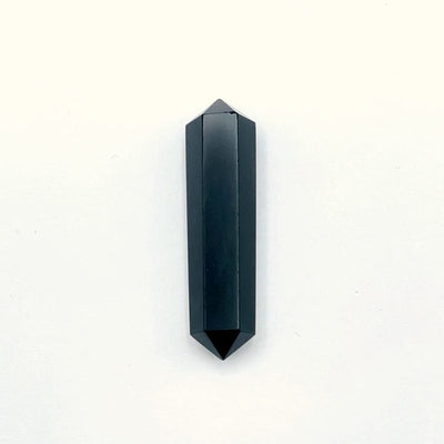 black obsidian double terminated pencil point gemstone on a white background