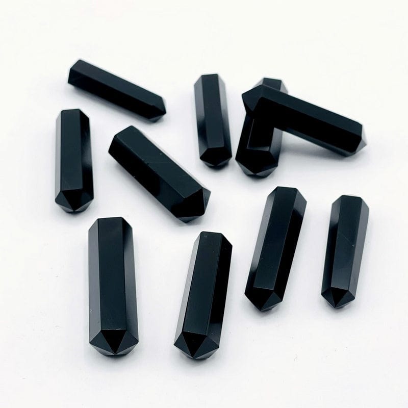 multiple black tourmaline double terminated gemstones showing different angles on a white background. 