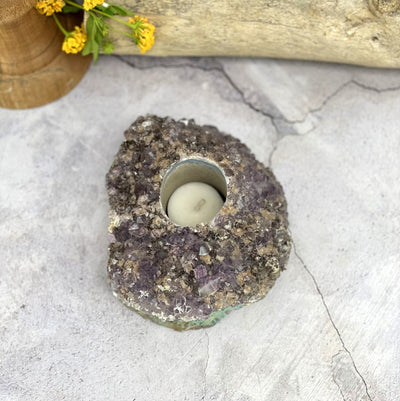 Amethyst cluster candle holder on a gray background.