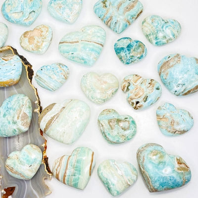 multiple caribbean calcite hearts with different patterns and sizes on a white background 