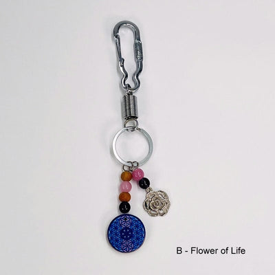keychain with a flower of life grid decorated with two wooden beads, a rose quartz bead and and amethyst bead. the lotus flower charm is decorated with a rose quartz and amethyst bead