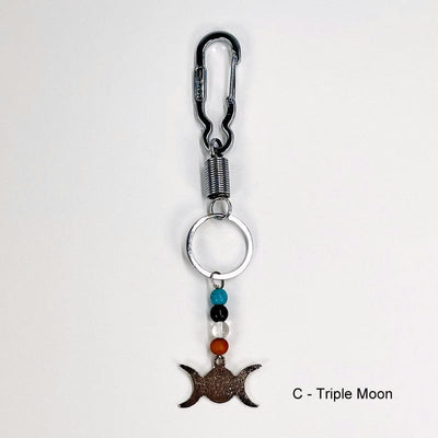 keychain with a triple moon charm decorated with a blue howlite, obsidian, crystal quartz and wooden bead