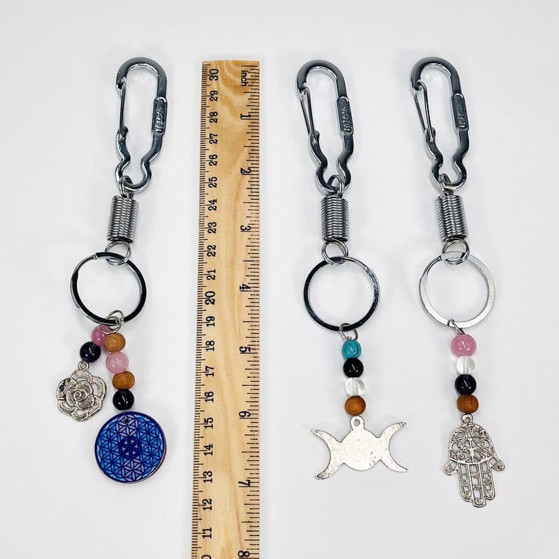 keychains next to a ruler for size reference 
