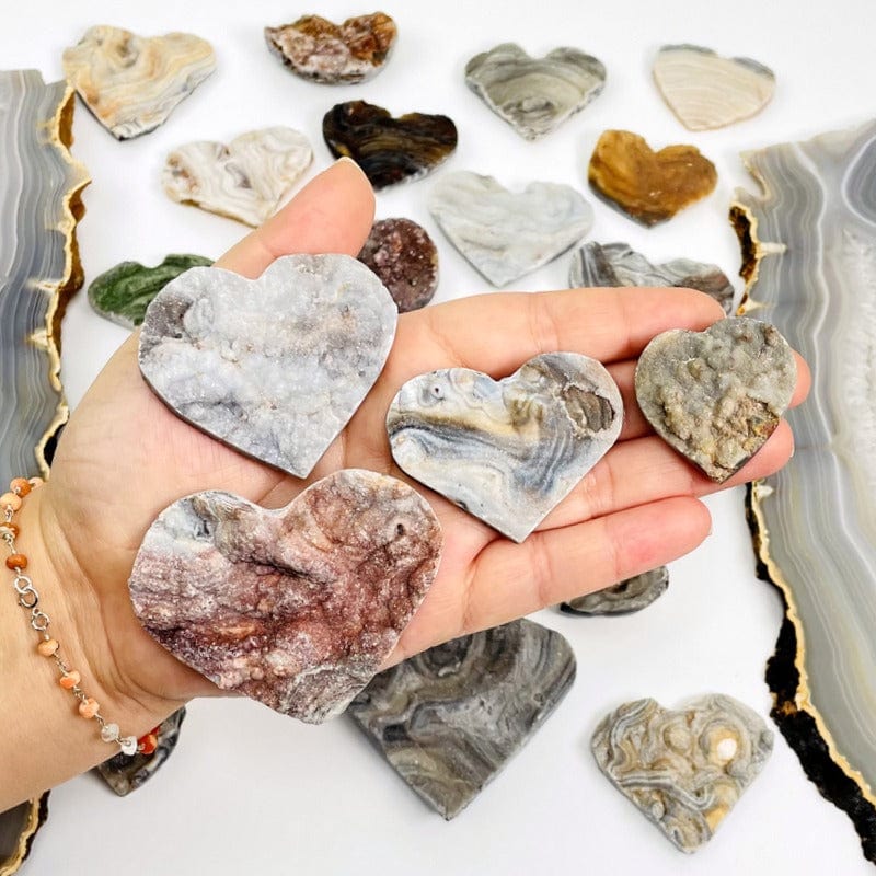 chalcedony hearts in hand showing different sizes 