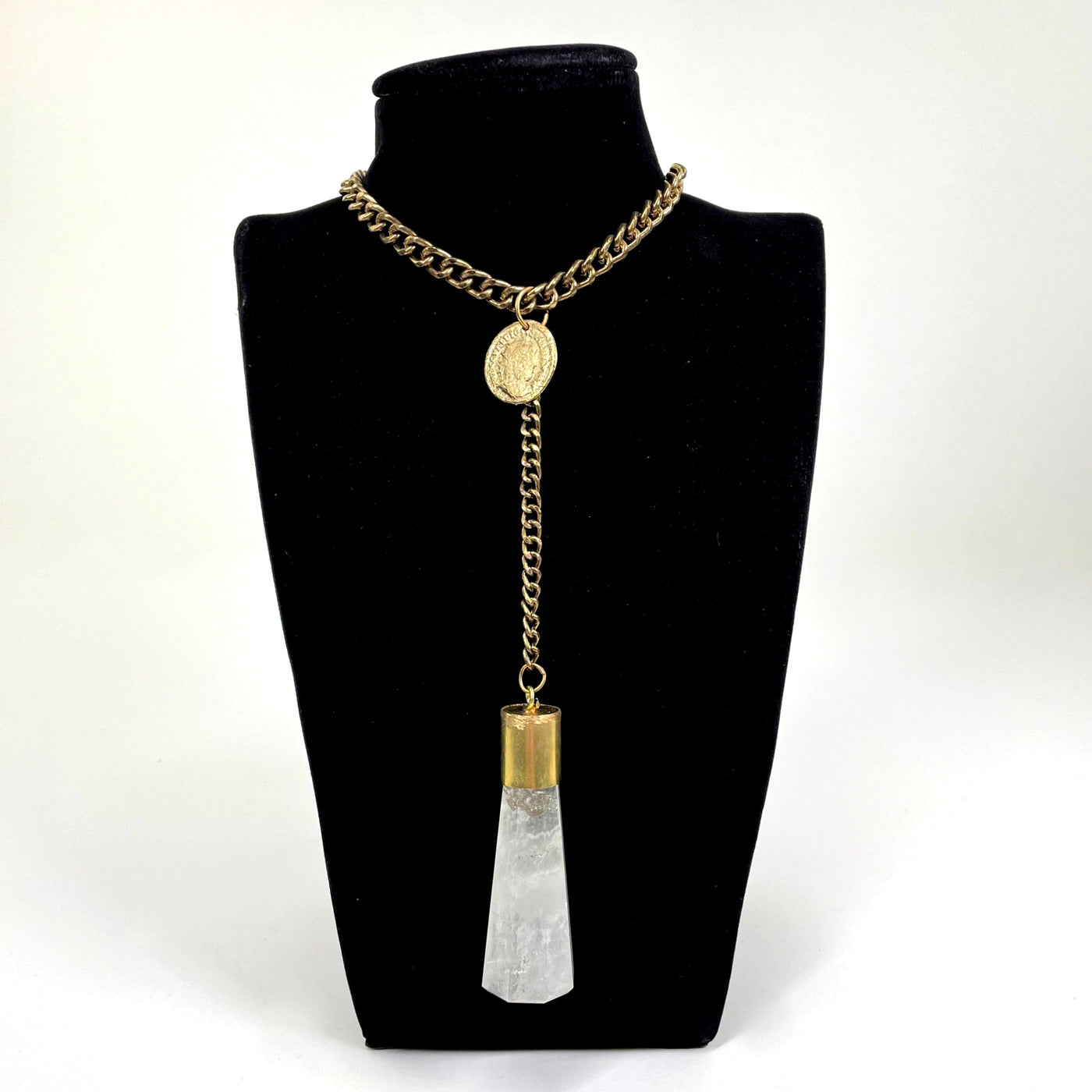 gold chain crystal quartz and coin pendant necklace on bust display in front of  white background