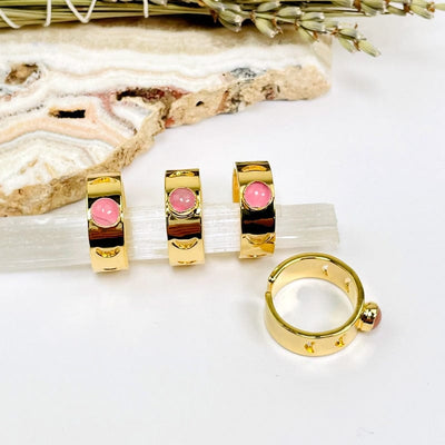gold moon phase adjustable rings with rose quartz center accent on white background 