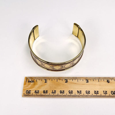 cuff bracelet next to a ruler for size reference 