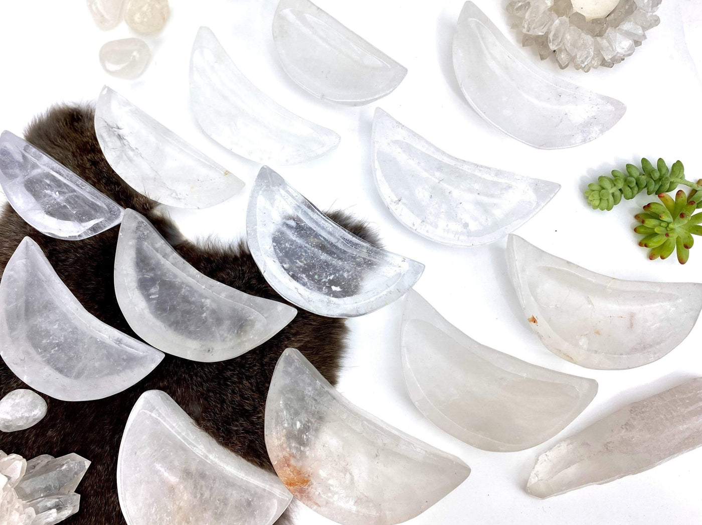 top view of multiple moon bowls laid out to show various sizes shapes inclusions on white background