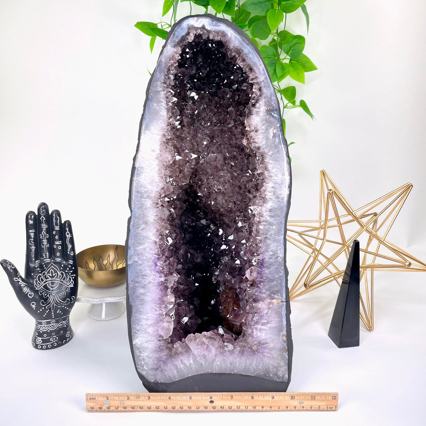 front of amethyst cave geode on display in front of backdrop with horizontal ruler for width reference