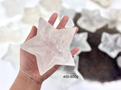 hand holding up 400-600g crystal quartz star dish