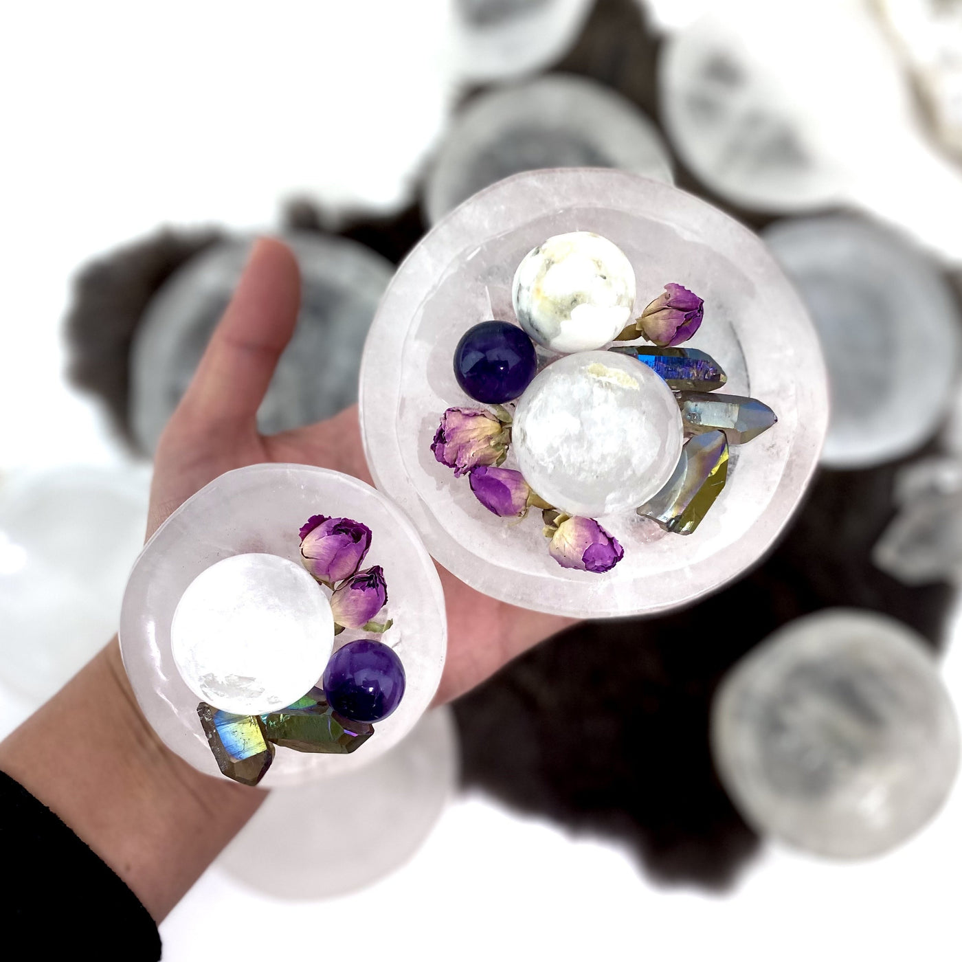 hand holding up 2 different sized crystal quartz round dishes