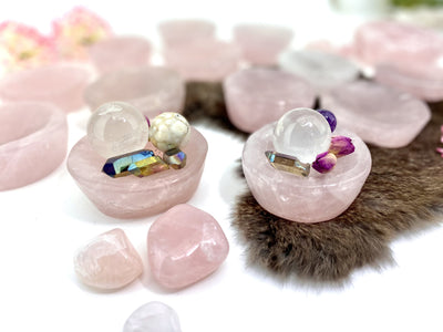 2 Rose Quartz Stone Round Dishes with crystals inside with others blurred in the background
