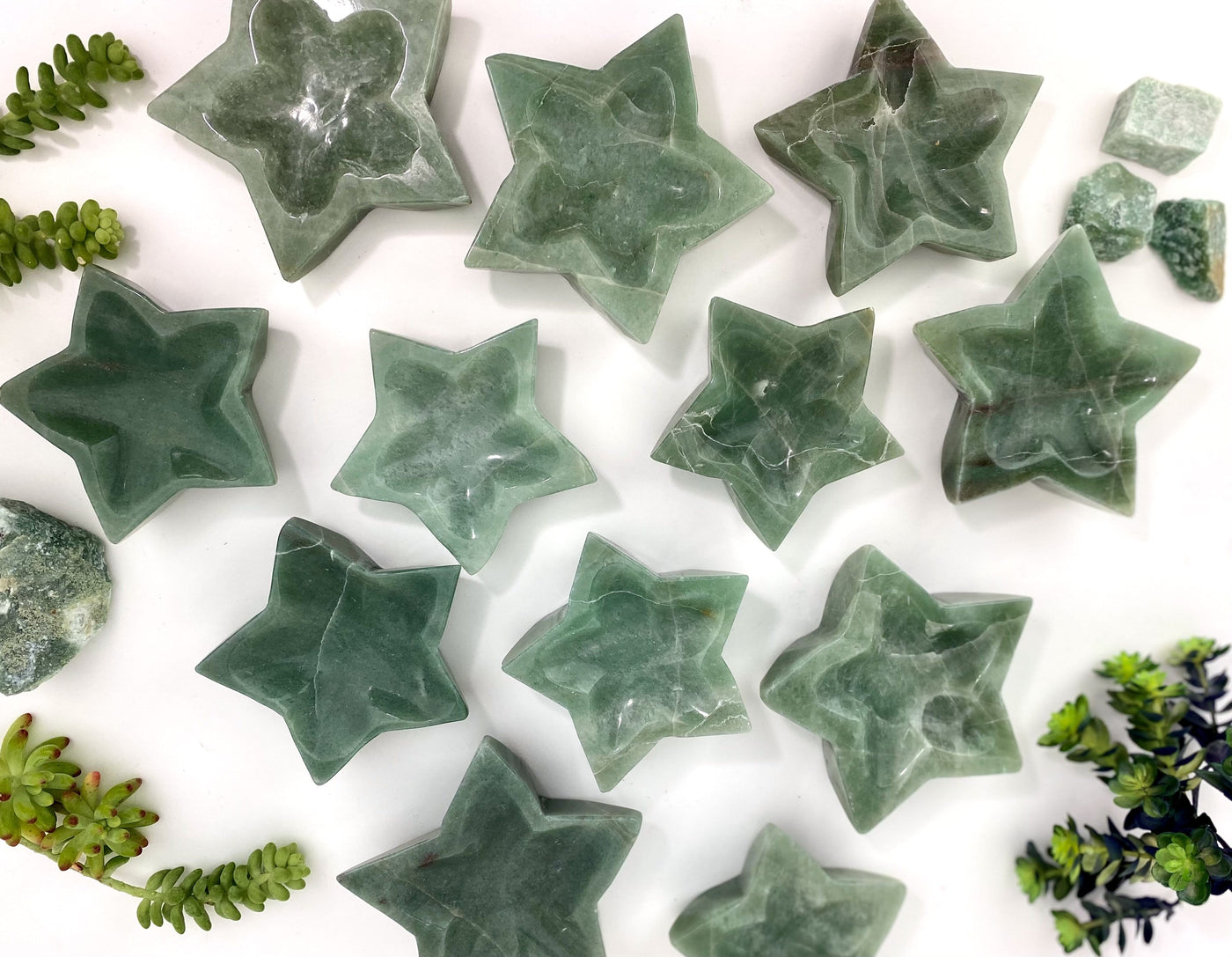 a bunch of green aventurine star dishes on a table