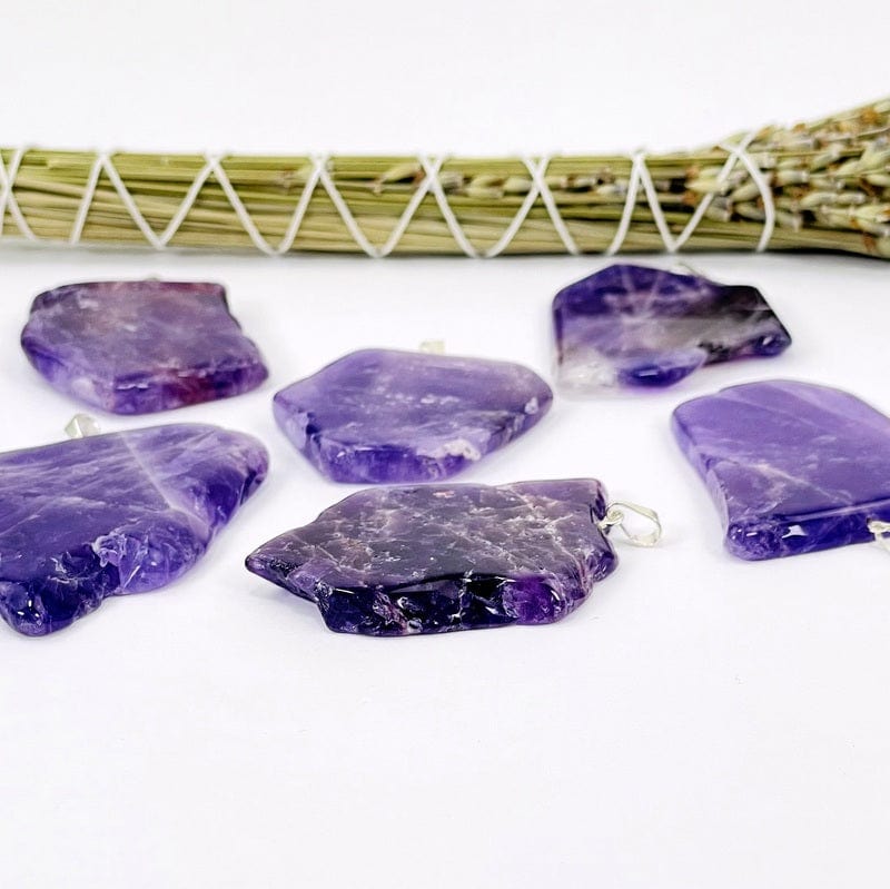 side shot of amethyst slab pendants with silver bail displaying the possible thickness 