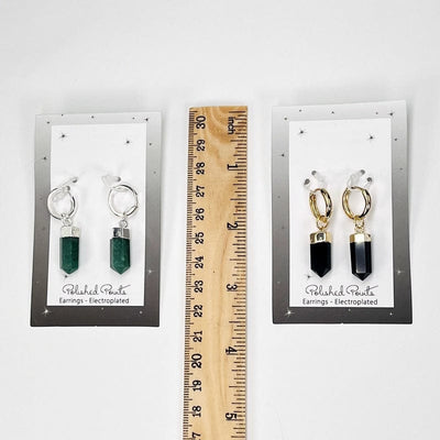 earrings on display card next to a ruler for size reference 