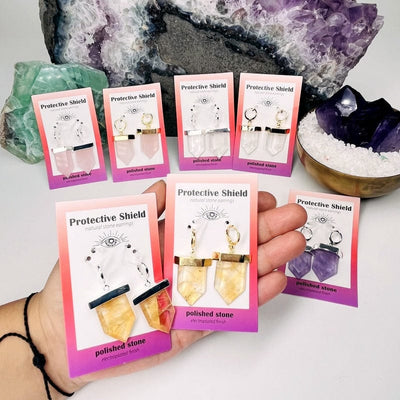 protective crystal shield earrings come in a display card. earrings in hand for size reference 