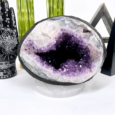 front of amethyst round cave geode on display in front of backdrop