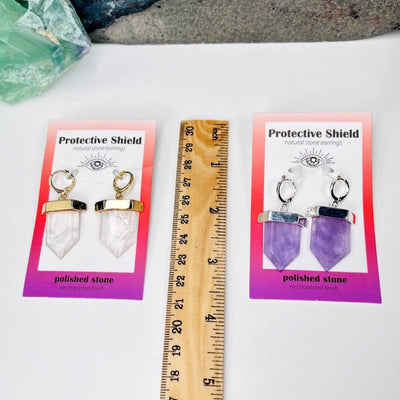 earrings next to a ruler for size reference 