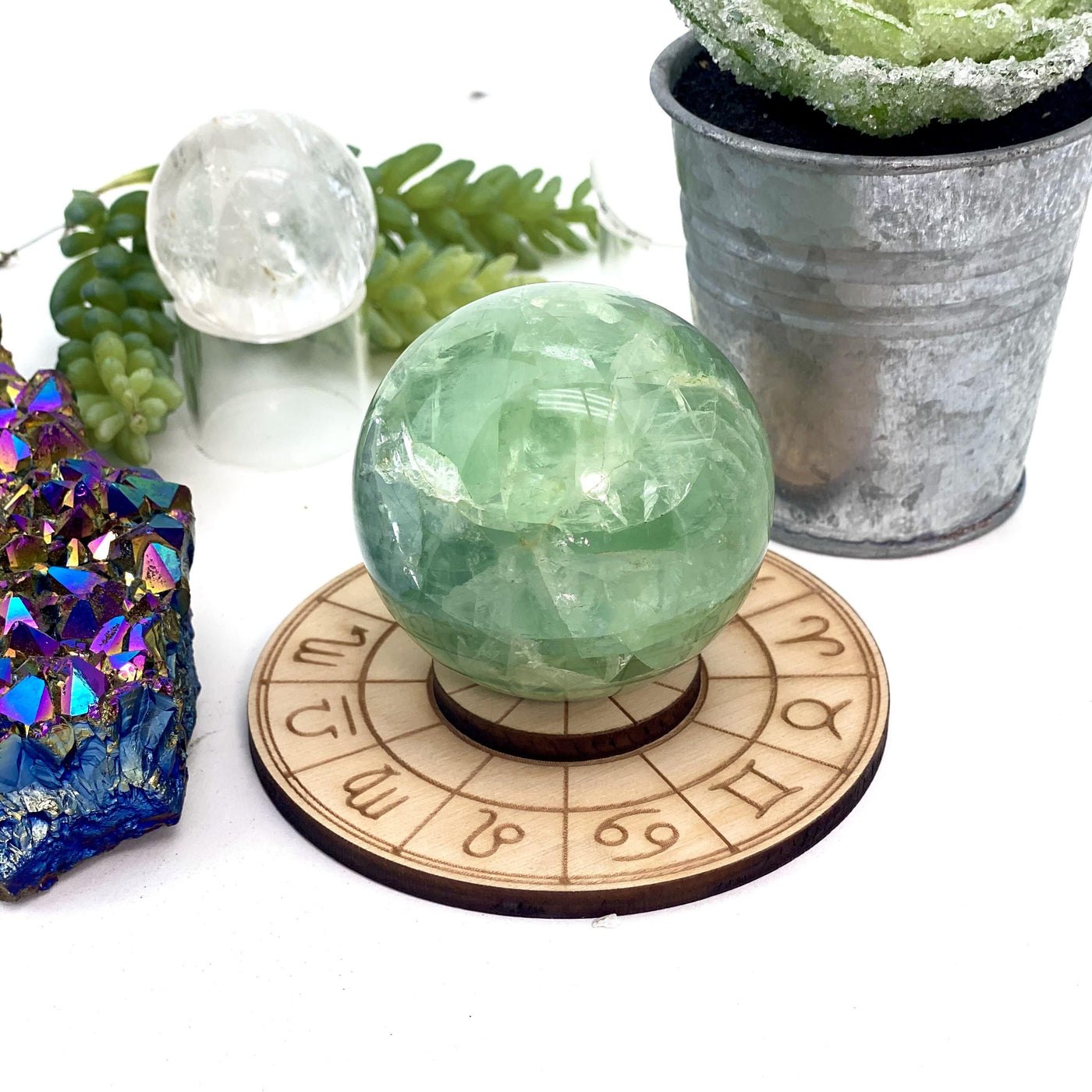 Wooden sphere stand with zodiac symbols.  PIctured with a green fluorite sphere on it.