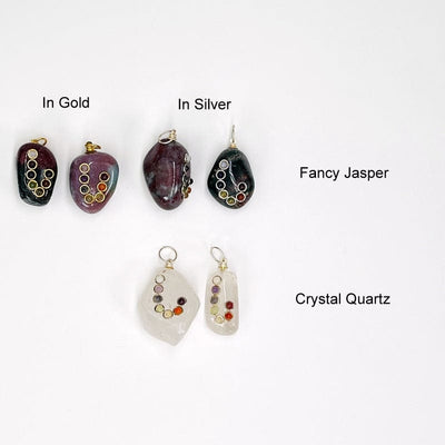 tumbled stones with a chakra accent displayed to show the available stones. all come with either a silver or gold bail. available in fancy jasper and crystal quartz