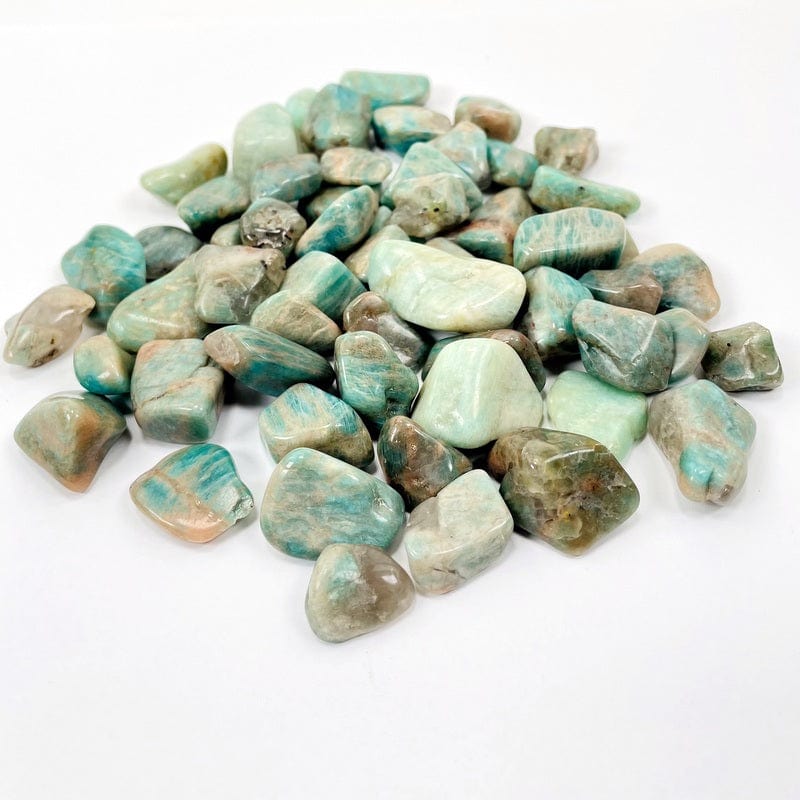 half a pound of amazonite small tumbled stones on a white background 