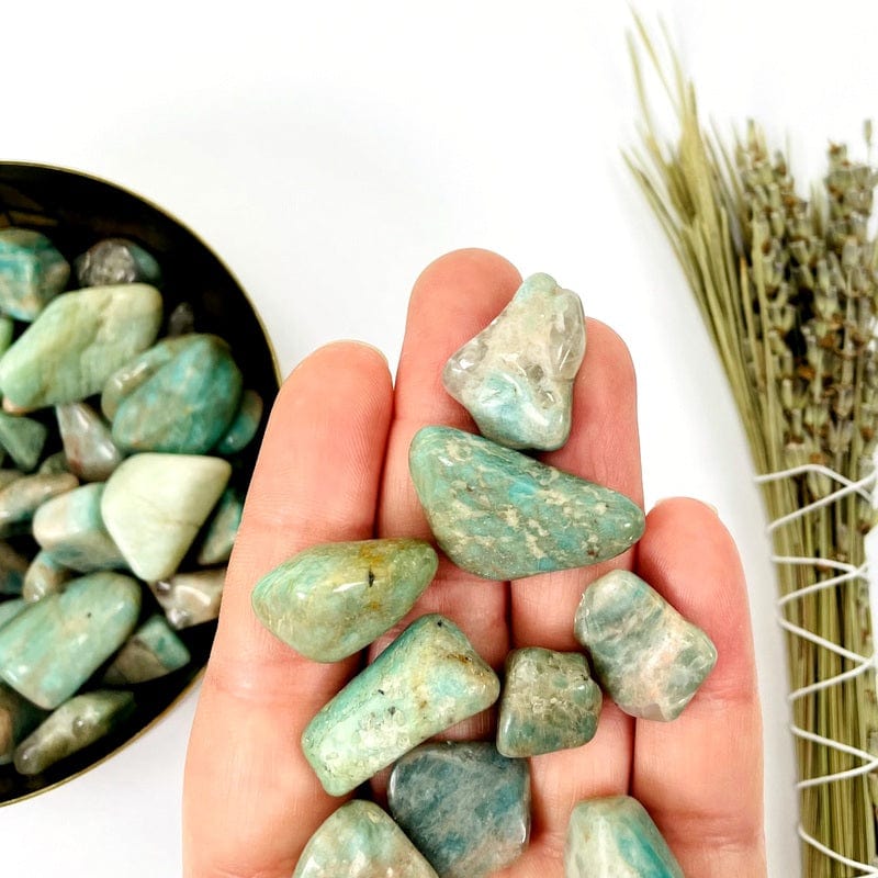 amazonite small tumbled stones in hand for size reference 