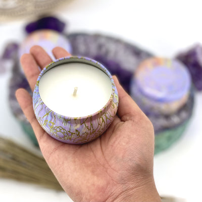 hand holding up opened Meditation Candle Tin with decorations blurred in the background