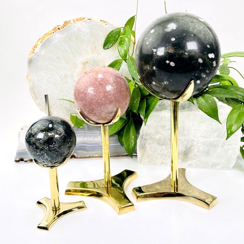 Small medium and large gold sphere stands with assorted crystal spheres on them.
