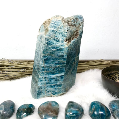 Blue Apatite Polished Point Chunk with decorations surrounding it