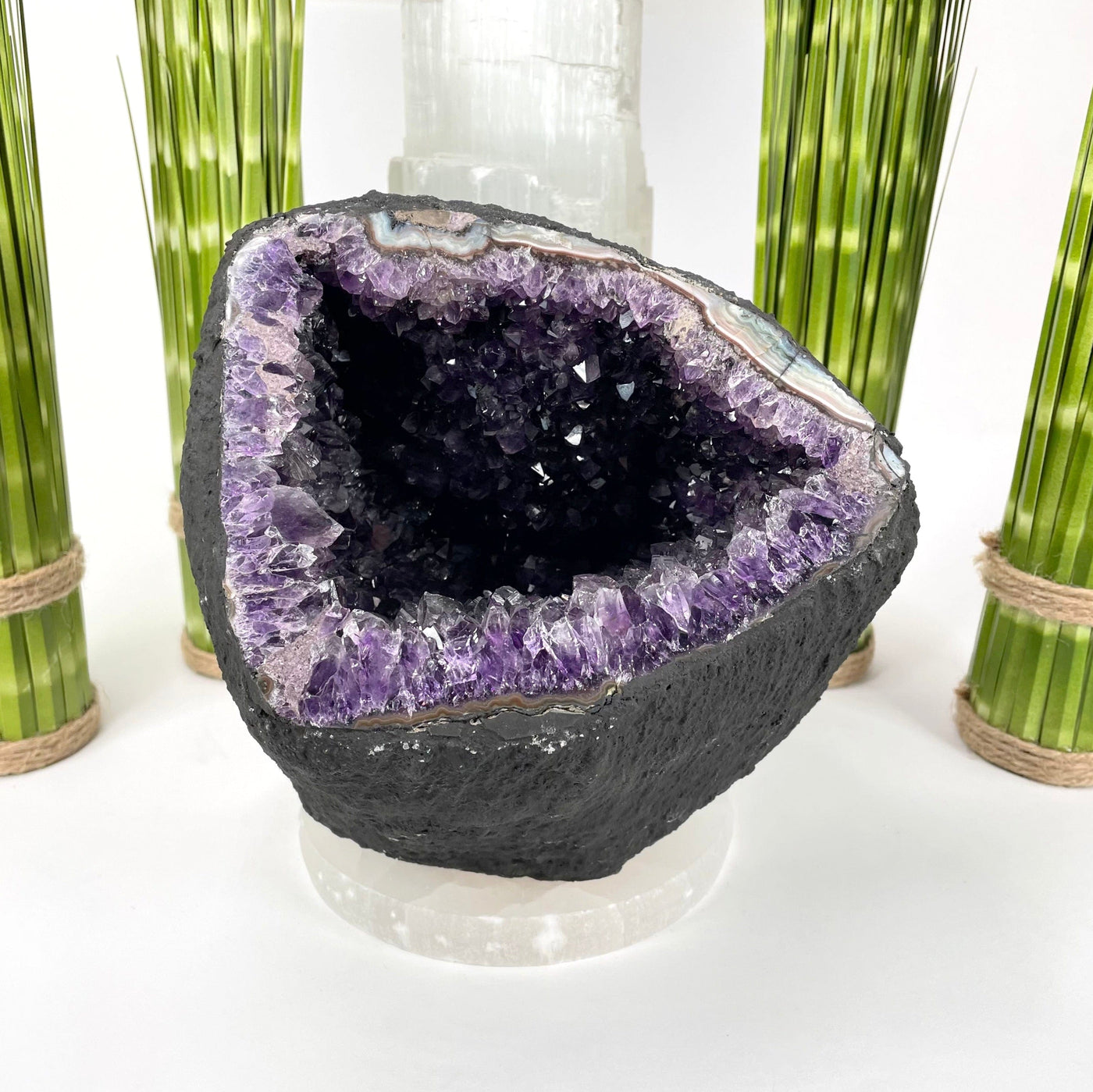 front of amethyst round cave geode on display in front of backdrop