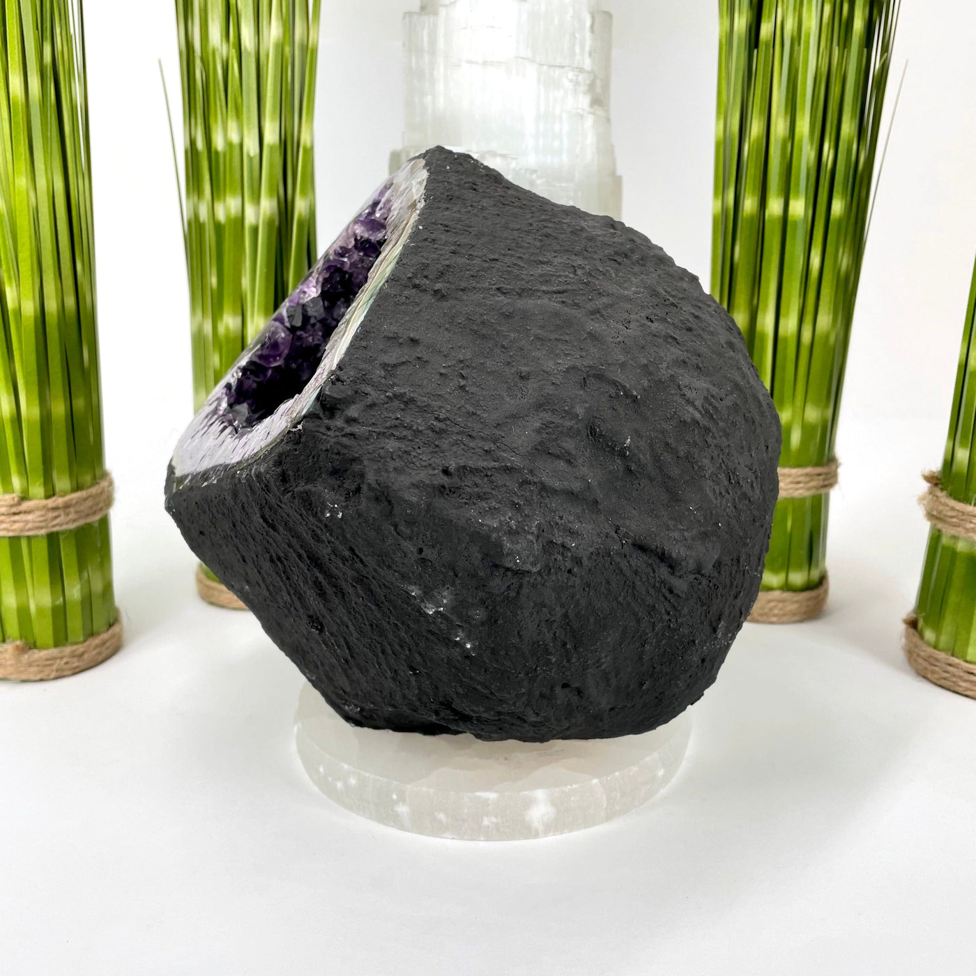 side of amethyst round cave geode on display in front of backdrop