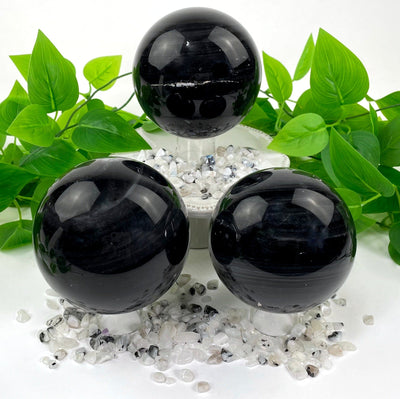three black agate polished spheres on display for possible variations