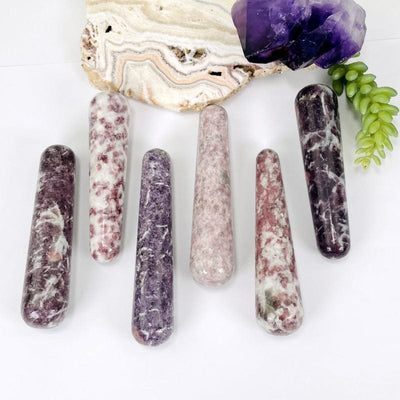 multiple lepidolite massage wands displaying the different sizes and color shades 