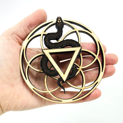 snake sacred geometry wooden sphere stand in hand over white background for size reference