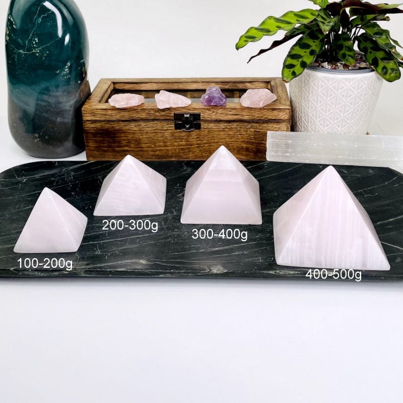 pink calcite pyramids next to their weight in grams 