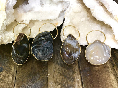 Four Agate Geode Enhydro Pendants on a dark background with geodes.