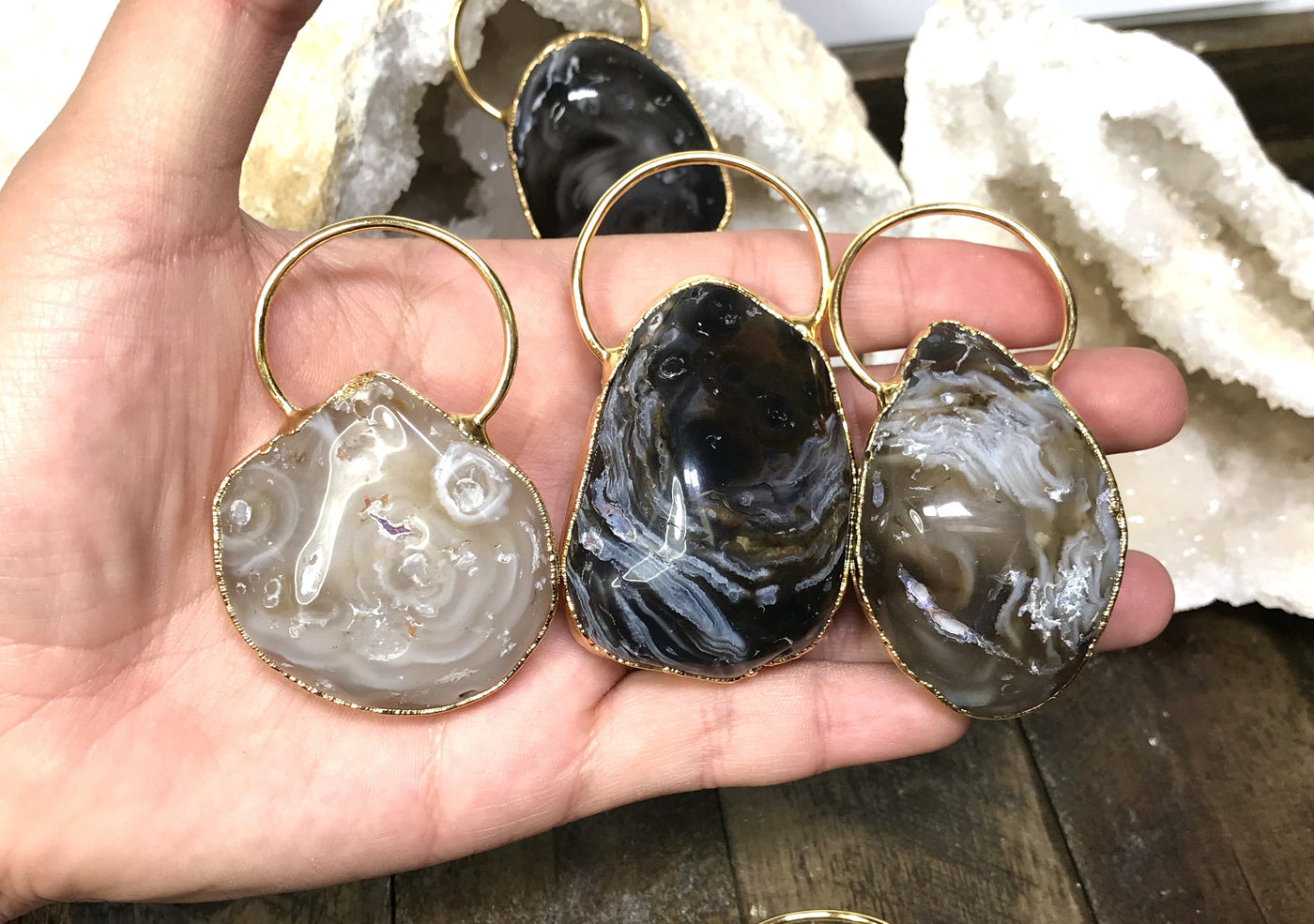 Three Agate Geode Enhydro Pendants in a hand.