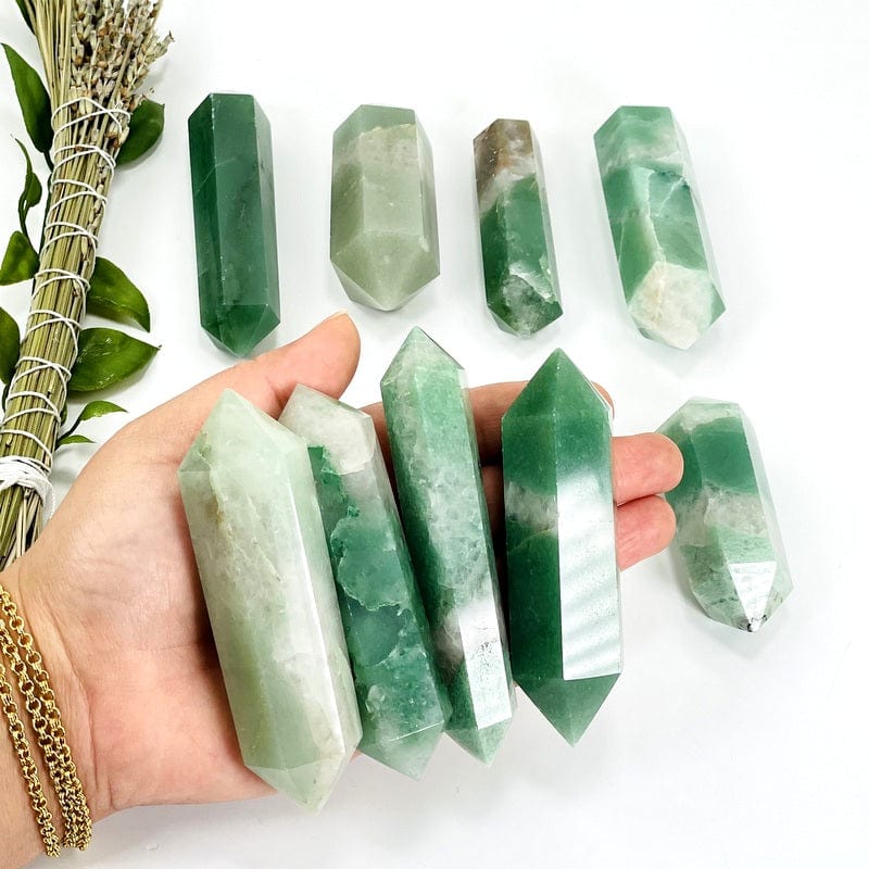 green and white quartz double terminated points in hand showing different sizes 