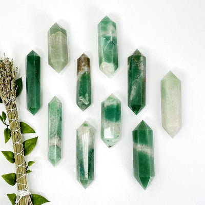 multiple green and white quartz double terminated points showing different sizes and patterns 