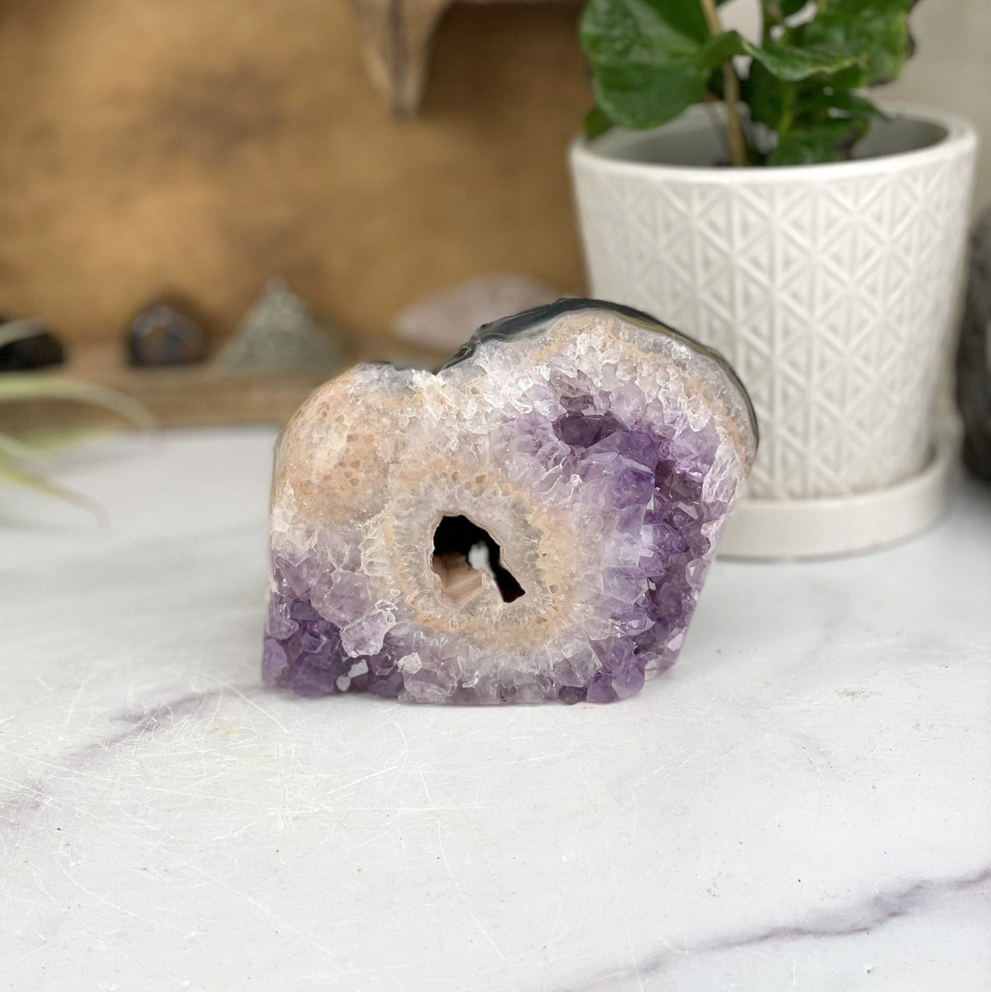 Amethyst Crystal Cut Base Stone with decorations in the background