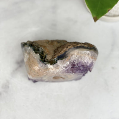 top view of Amethyst Crystal Cut Base Stone on marble background
