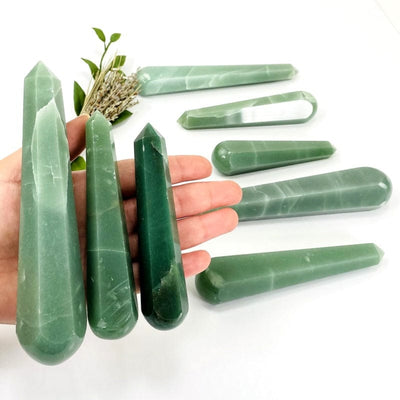 green quartz polished massage points in hand showing different sizes 